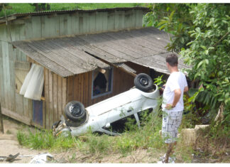 Carro cai sobre casa na Variante